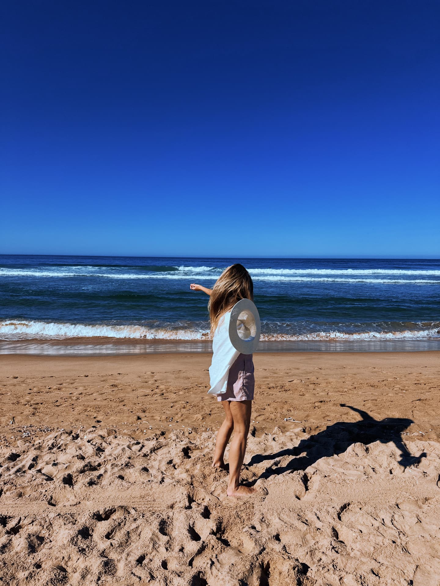 Relinde walking on a sandy beach in Portugal